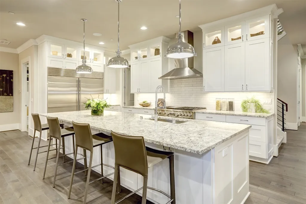 Luxury kitchen remodel featuring white custom cabinetry, a grey island, silver accents, display cabinets, and under-cabinet lighting