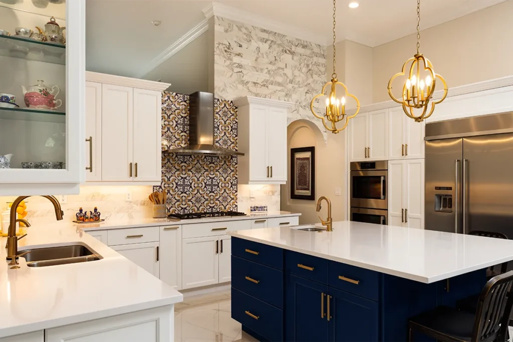 Luxury kitchen remodel featuring white shaker cabinets, a navy blue island, quartz countertops, designer pendant lighting, and custom finishes
