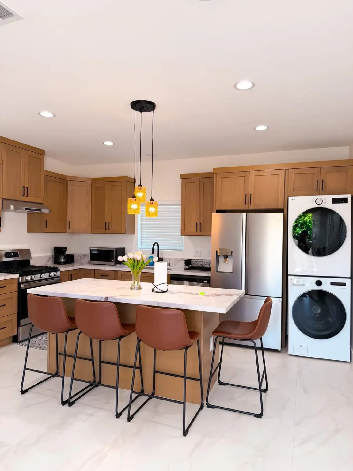 Kitchen with stacked laundry in Los Angeles by Athenian Builders