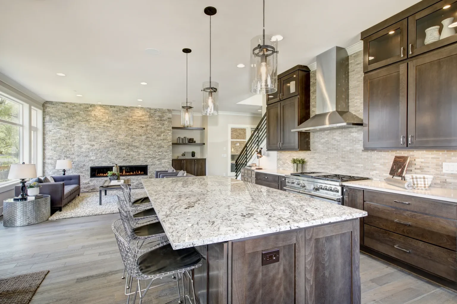 Open concept kitchen island stone fireplace in Encino by Athenian Builders