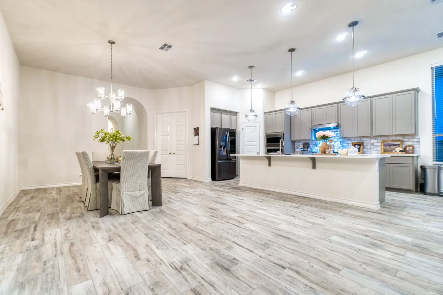 Open plan dining wood look tile floor in North Hollywood by Athenian Builders