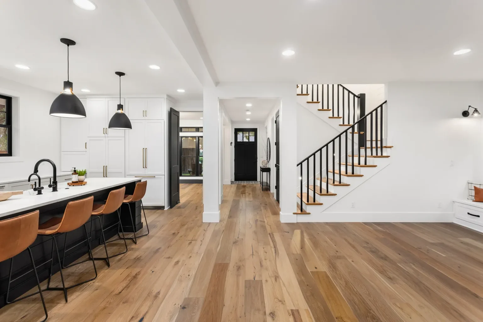 Wide plank oak flooring staircase entry in West Hollywood by Athenian Builders